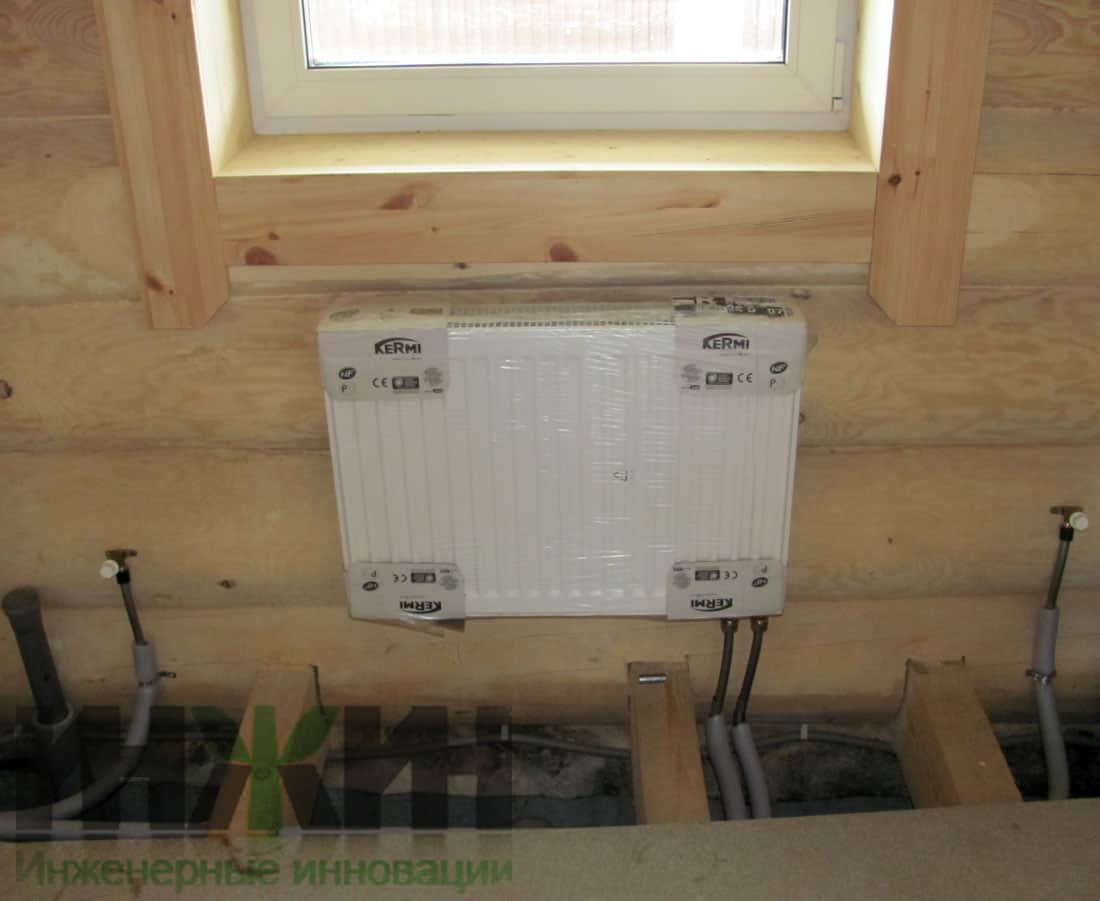 Монтаж отопления в деревянном дому, установка панельного радиатора Kermi под окном